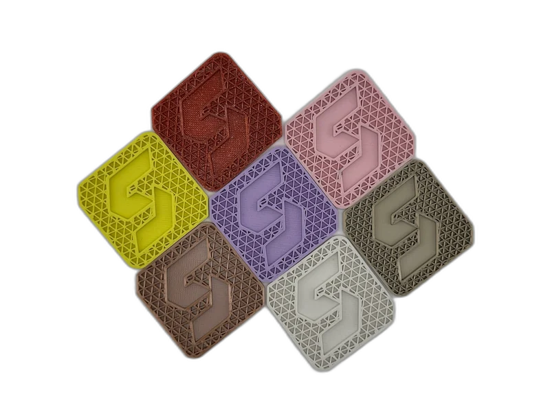 Seven FDM 3D printed PLA coasters in different colors showing PLA's wide color range