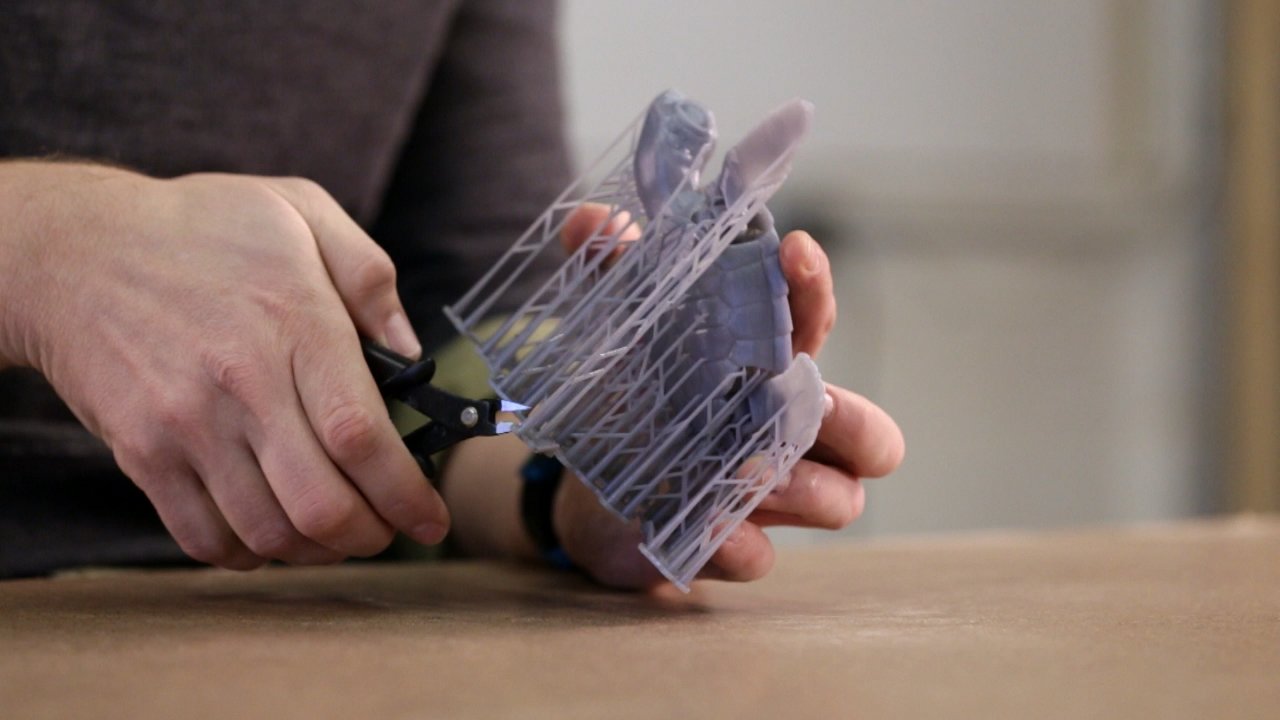 Removing support structures from an SLA resin part with flush cutters before sanding
